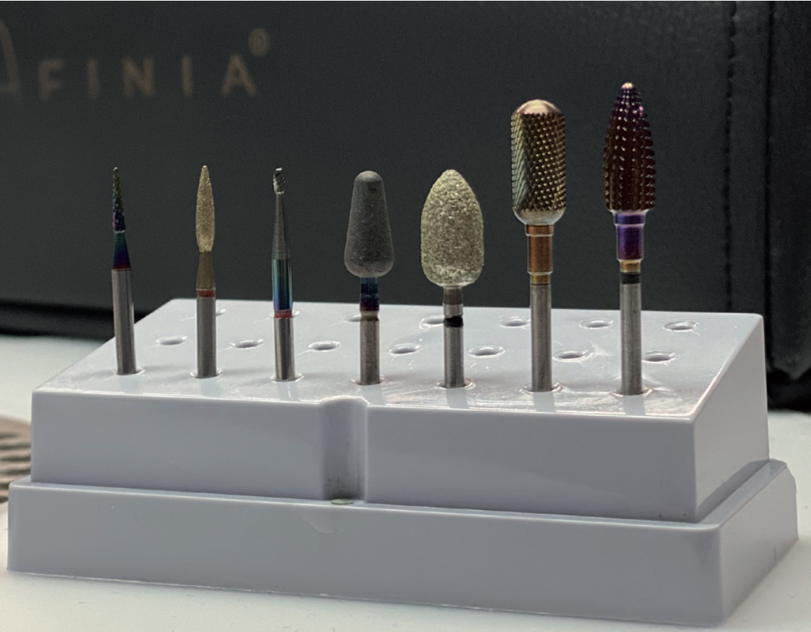 Zestaw najpopularniejszych frezów stosowanych w stylizacji paznokci (szczelinowiec, mały płomyk, mała szyszka, baryłka, duży płomyk, zaokrąglony walec, stożek)